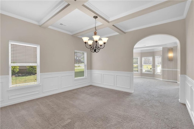 unfurnished room featuring arched walkways, beamed ceiling, and light carpet