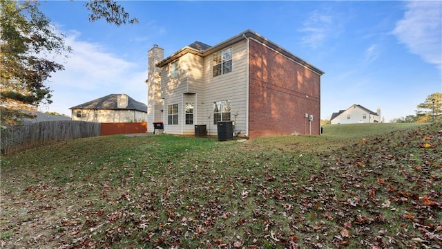 back of house featuring a lawn and cooling unit