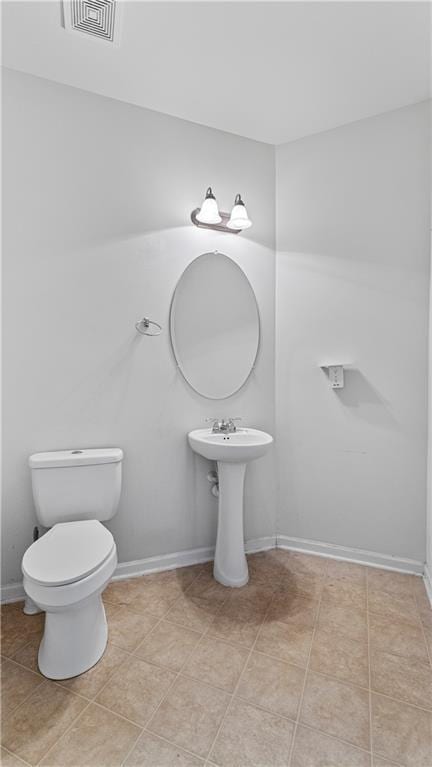 bathroom with toilet and tile patterned flooring