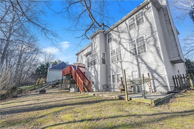 back of property featuring a lawn and a deck