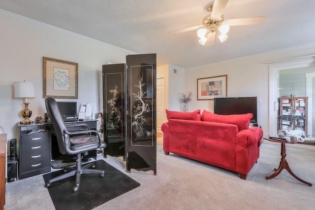 carpeted office space featuring visible vents, ornamental molding, a ceiling fan, and a textured ceiling