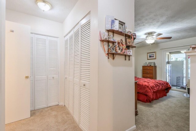 corridor with a textured ceiling and carpet