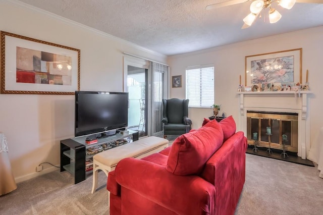 living room featuring crown molding, ceiling fan, carpet, and a glass covered fireplace