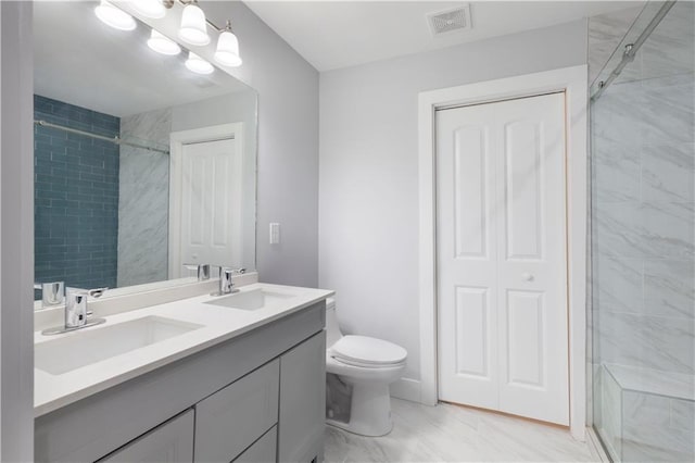 bathroom with tiled shower, toilet, and vanity