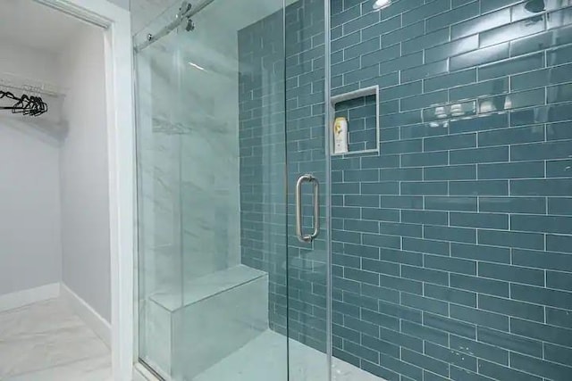 bathroom with a shower with door