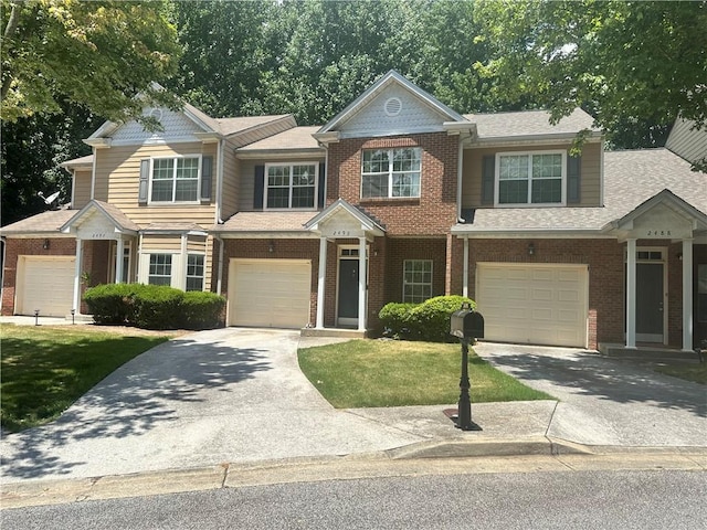 view of front of property featuring a front yard, brick siding, concrete driveway, and an attached garage