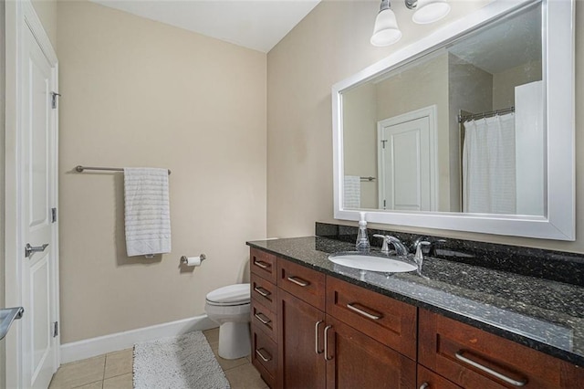 bathroom with tile patterned flooring, vanity, and toilet