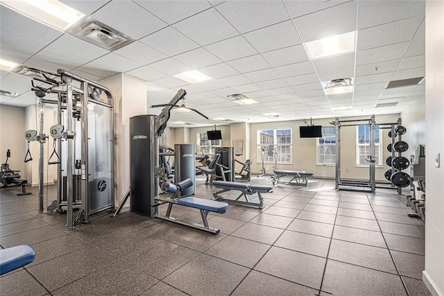exercise room with a drop ceiling and baseboards