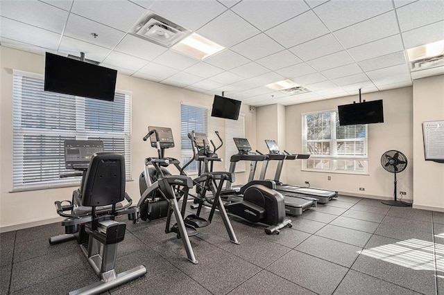 workout area with a paneled ceiling and baseboards