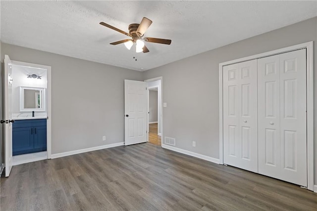 679 Creek View Dr, Lawrenceville, GA 30044 - unfurnished bedroom with dark wood-style flooring, baseboards, a closet, ensuite bath, and a textured ceiling