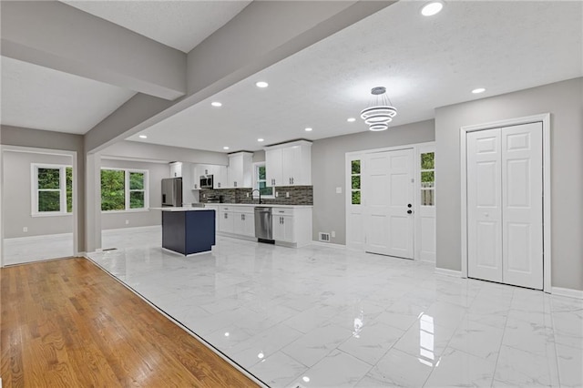 679 Creek View Dr, Lawrenceville, GA 30044 - kitchen with stainless steel appliances, baseboards, recessed lighting, white cabinets, and light marble finish flooring