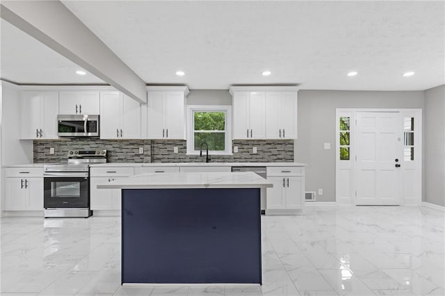 679 Creek View Dr, Lawrenceville, GA 30044 - kitchen with appliances with stainless steel finishes, a sink, light marble finish flooring, decorative backsplash, and white cabinets