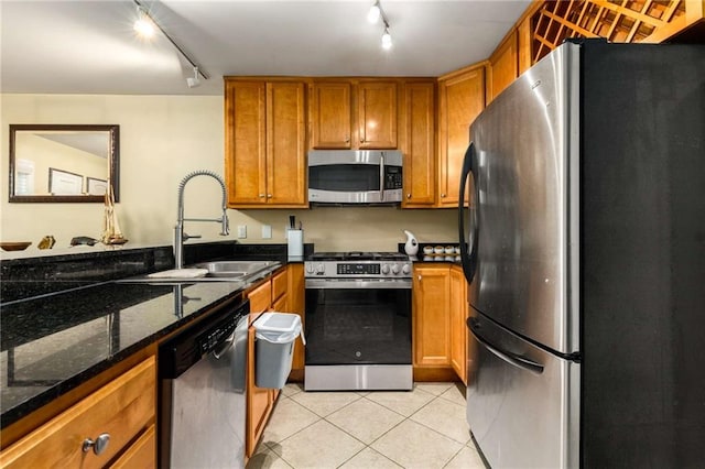 1445 Monroe Dr NE Unit 14B, Atlanta, GA 30324 - kitchen with appliances with stainless steel finishes, rail lighting, brown cabinetry, and light tile patterned flooring