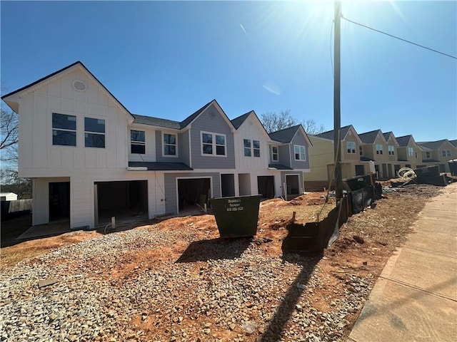 view of front of property with a residential view, board and batten siding, and an attached garage