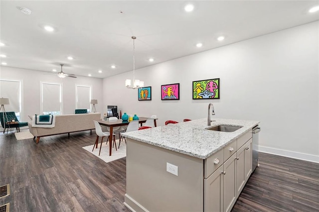 kitchen with a center island with sink, dark wood-type flooring, sink, and ceiling fan with notable chandelier