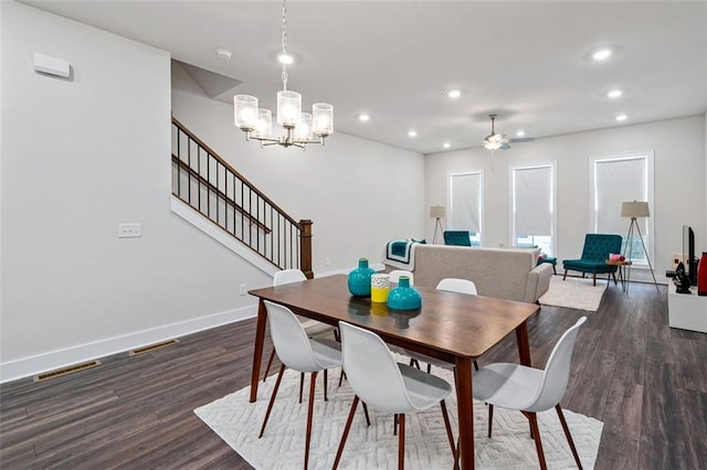 dining area featuring dark hardwood / wood-style floors and ceiling fan with notable chandelier