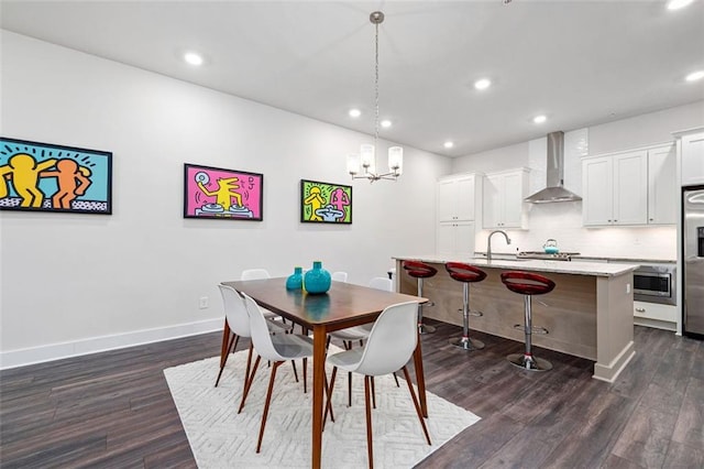 dining area featuring sink, dark hardwood / wood-style floors, and an inviting chandelier