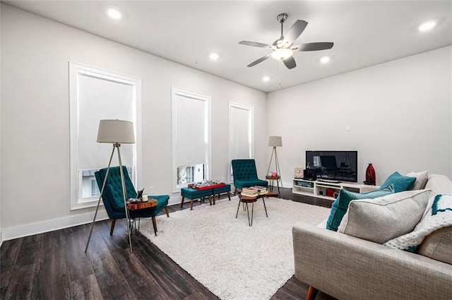 living room with ceiling fan and dark hardwood / wood-style flooring