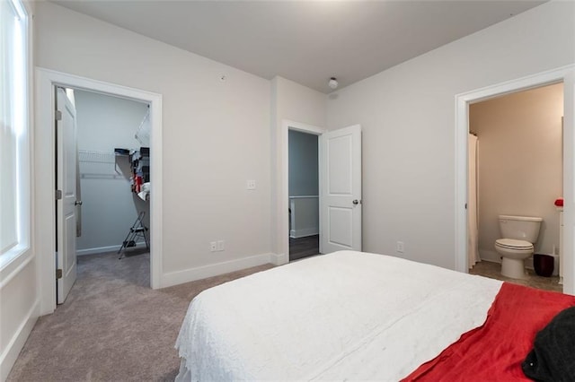 bedroom with ensuite bath, light colored carpet, a walk in closet, and a closet