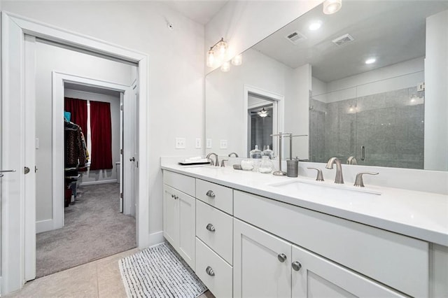 bathroom with a shower with door, dual sinks, tile floors, and oversized vanity