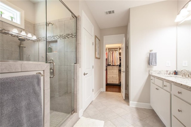 3678 Cresswind Pkwy SW, Gainesville, GA 30504 - bathroom with vanity, a shower stall, tile patterned flooring, a walk in closet, and baseboards