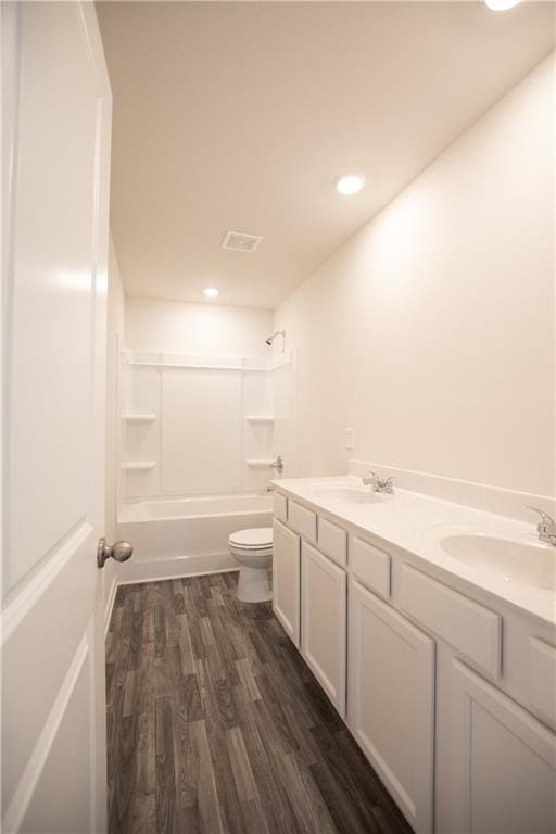 full bathroom with vanity, hardwood / wood-style floors,  shower combination, and toilet