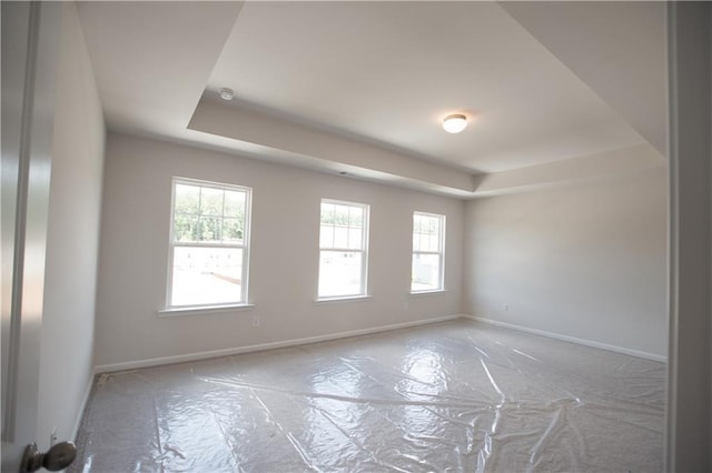 empty room with a wealth of natural light and a tray ceiling