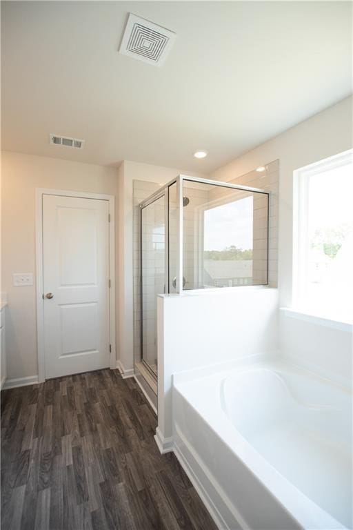 bathroom featuring vanity, independent shower and bath, and wood-type flooring