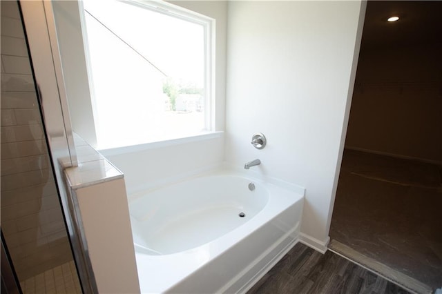 bathroom with shower with separate bathtub and hardwood / wood-style floors