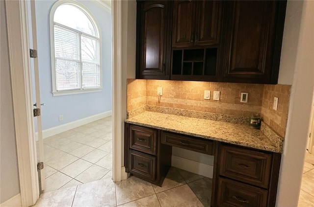 interior space with dark brown cabinets, light stone countertops, and decorative backsplash