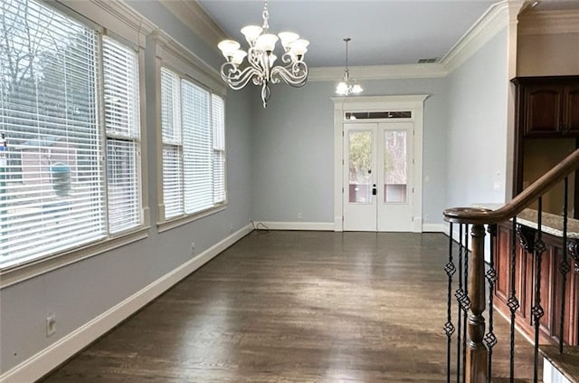 foyer entrance with french doors, an inviting chandelier, dark wood-type flooring, and crown molding