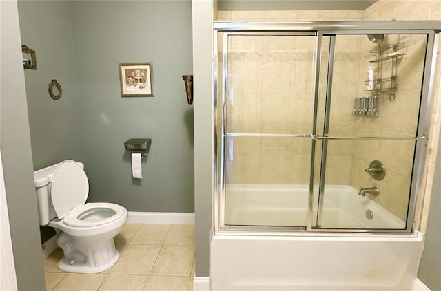 bathroom with tile patterned floors, toilet, and combined bath / shower with glass door