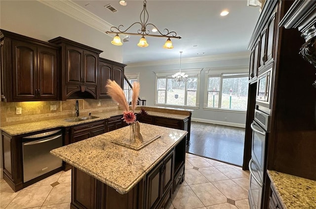 kitchen with a center island, stainless steel appliances, sink, hanging light fixtures, and dark brown cabinets