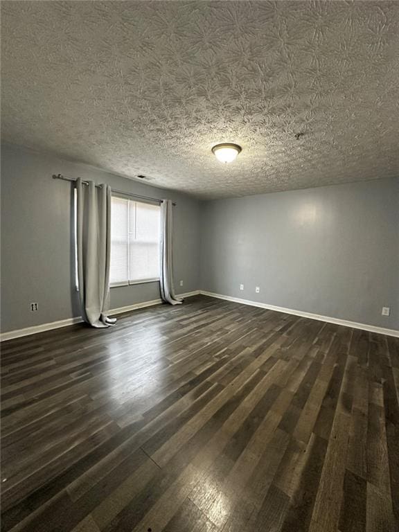 unfurnished room with a textured ceiling and dark wood-type flooring