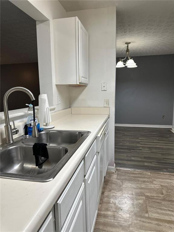 kitchen featuring sink, white cabinets, and hanging light fixtures