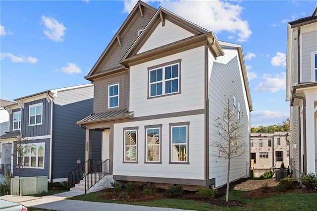 view of front of home with a standing seam roof, central AC unit, and metal roof