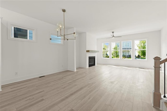 1937 Quarry Park Pl NW, Atlanta, GA 30318 - unfurnished living room with light wood-style flooring, a glass covered fireplace, a chandelier, and baseboards