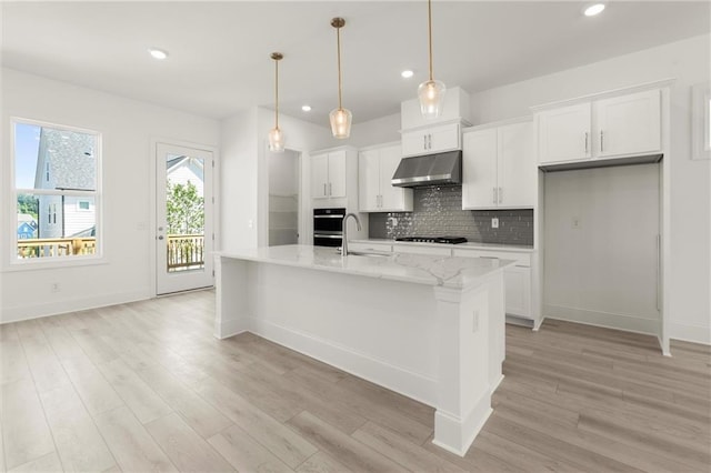 1937 Quarry Park Pl NW, Atlanta, GA 30318 - kitchen featuring under cabinet range hood, a sink, light wood-style floors, white cabinetry, and recessed lighting