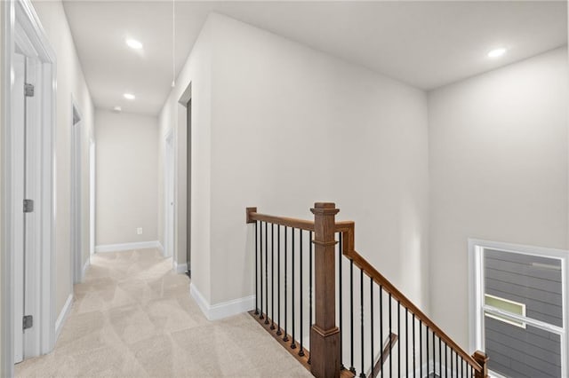 hall with recessed lighting, attic access, light carpet, an upstairs landing, and baseboards