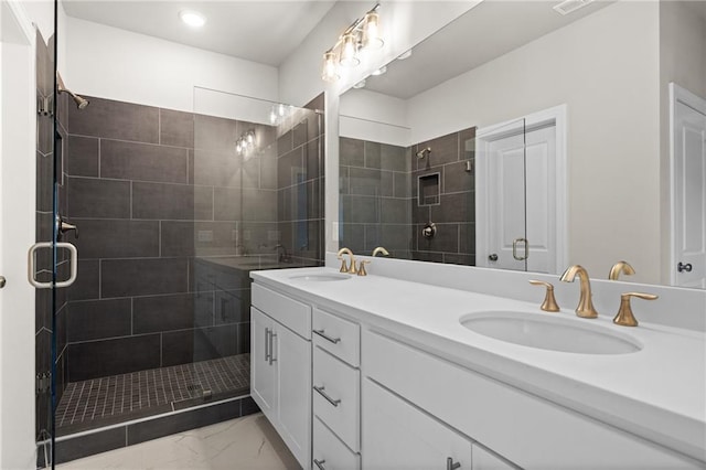 full bathroom featuring a stall shower, marble finish floor, a sink, and double vanity