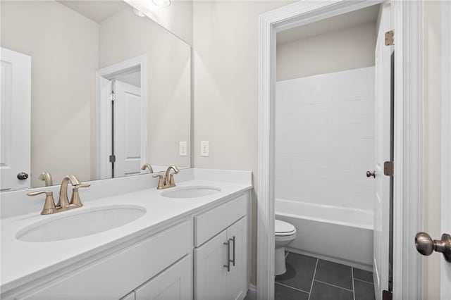 bathroom with toilet, tile patterned flooring, double vanity, and a sink