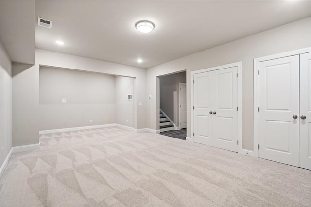 below grade area with light carpet, recessed lighting, visible vents, and baseboards