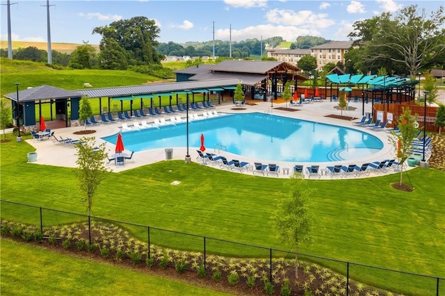 pool with fence, a patio, and a yard