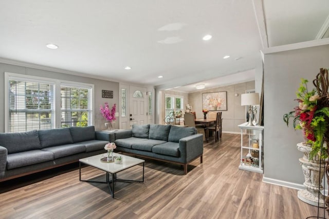 living area with crown molding, recessed lighting, light wood-style floors, and baseboards