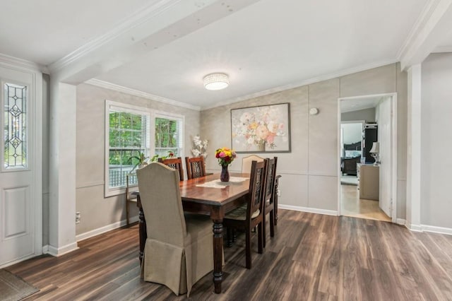 dining area featuring dark wood finished floors, crown molding, and baseboards