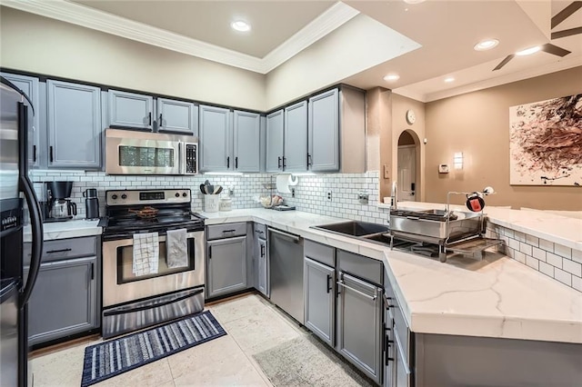 3777 Peachtree Rd NE Unit 438, Brookhaven, GA 30319 - kitchen featuring appliances with stainless steel finishes, crown molding, a peninsula, light stone counters, and backsplash