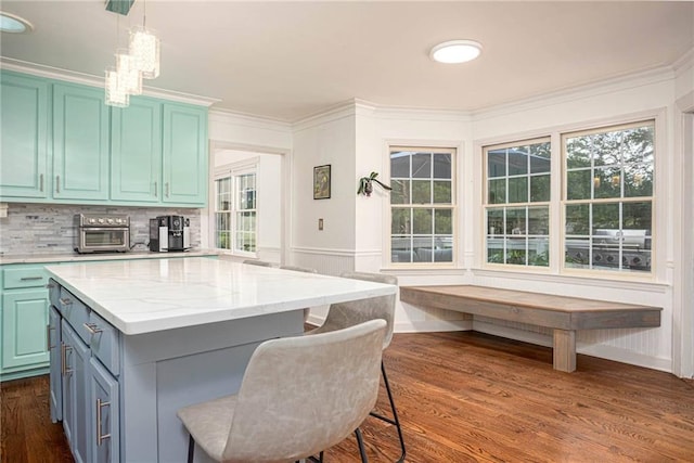 2355 Quail Creek Ter, Buford, GA 30519 - kitchen with a center island, dark wood finished floors, healthy amount of natural light, a kitchen bar, and ornamental molding