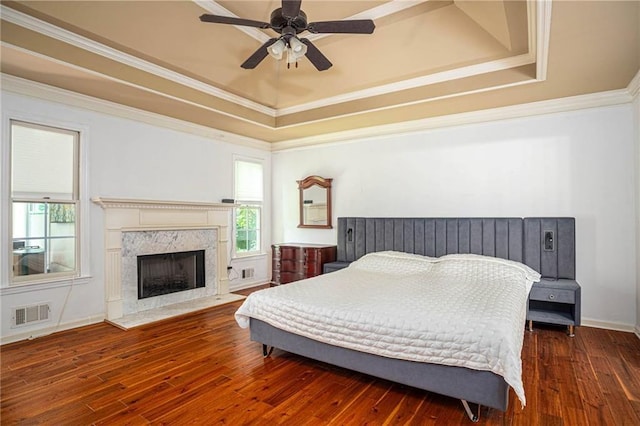 2355 Quail Creek Ter, Buford, GA 30519 - bedroom with a tray ceiling, hardwood / wood-style flooring, crown molding, a premium fireplace, and a ceiling fan