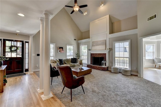 living area featuring high vaulted ceiling, visible vents, ornate columns, and a healthy amount of sunlight