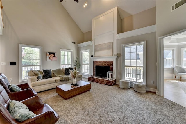 living room featuring a healthy amount of sunlight, high vaulted ceiling, and visible vents